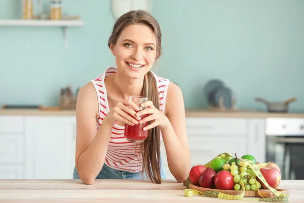 Mujer joven bebiendo jugo saludable en la cocina. Concepto de dieta —  Fotos de Stock