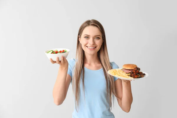 拥有健康和不健康食物的妇女，背景浅。 饮食概念 — 图库照片