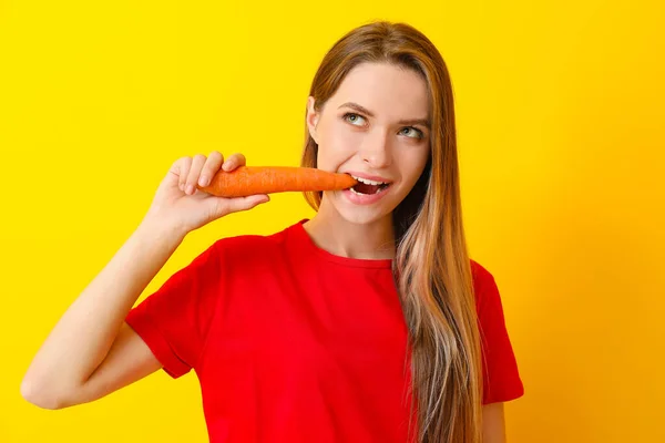 Mulher comendo cenoura saudável no fundo da cor. Conceito de dieta — Fotografia de Stock