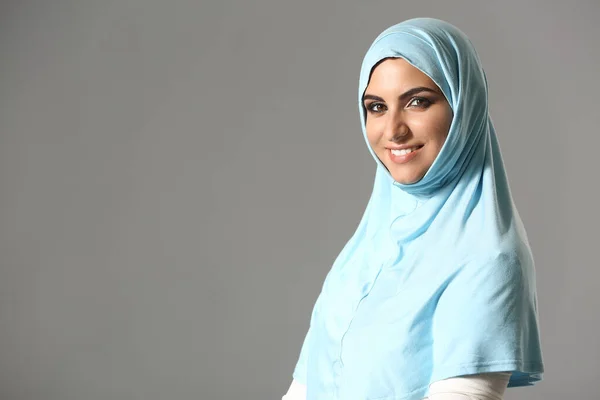 Portrait of beautiful Muslim woman on grey background — Stock Photo, Image