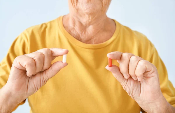 Mujer mayor con pastillas sobre fondo claro, primer plano —  Fotos de Stock