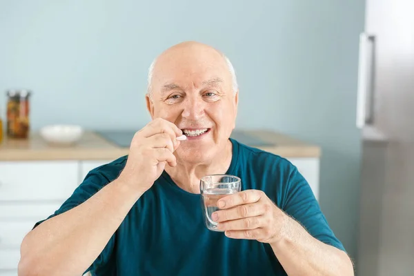 Anciano tomando medicamentos en casa —  Fotos de Stock