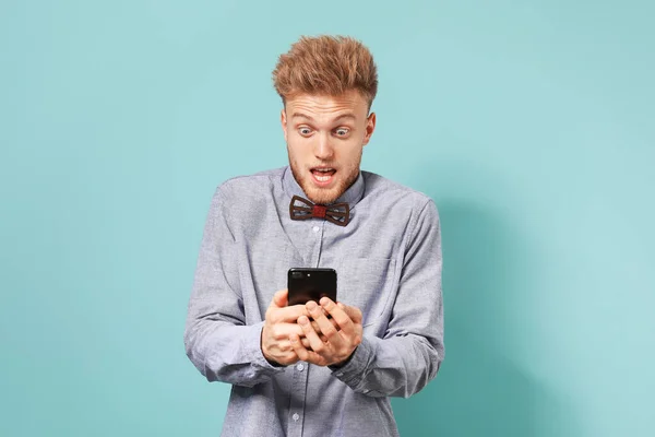 Retrato del hombre sorprendido con teléfono móvil sobre fondo de color —  Fotos de Stock