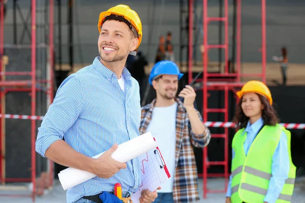 Portrait of male architect and his team in building area — Stock Photo, Image