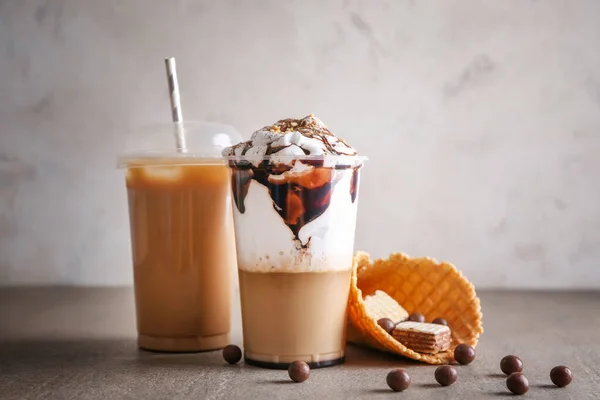 Bekers lekkere frappe koffie en snoepjes op tafel — Stockfoto