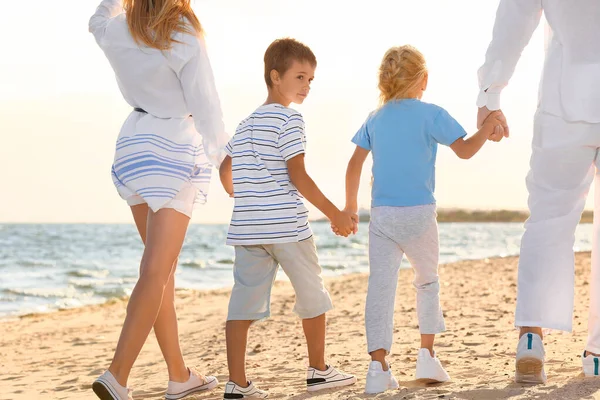 Mutlu bir aile deniz kıyısında yürüyor — Stok fotoğraf