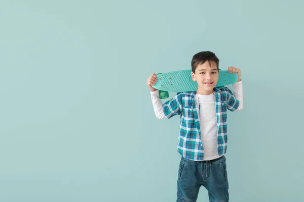 Aranyos divatos fiú gördeszka a színes háttér — Stock Fotó