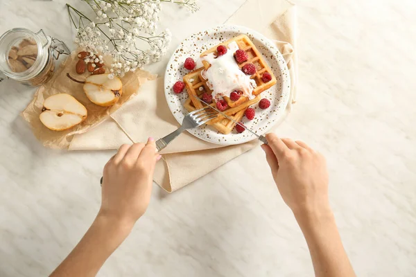 Mulher comendo waffles saborosos com sorvete na mesa, vista superior — Fotografia de Stock