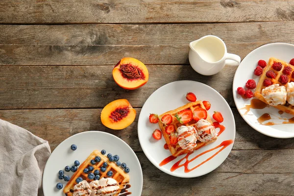 Plates with tasty waffles, berries and ice cream on table — Stock Photo, Image