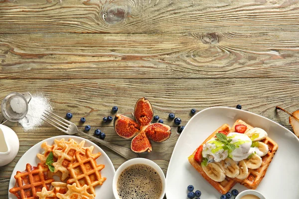 Plates with tasty waffles, ice cream and coffee on wooden table — Stock Photo, Image