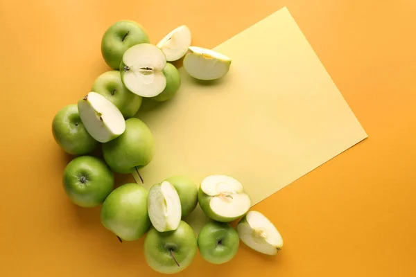 Fresh ripe apples with paper sheet on color background — Stock Photo, Image