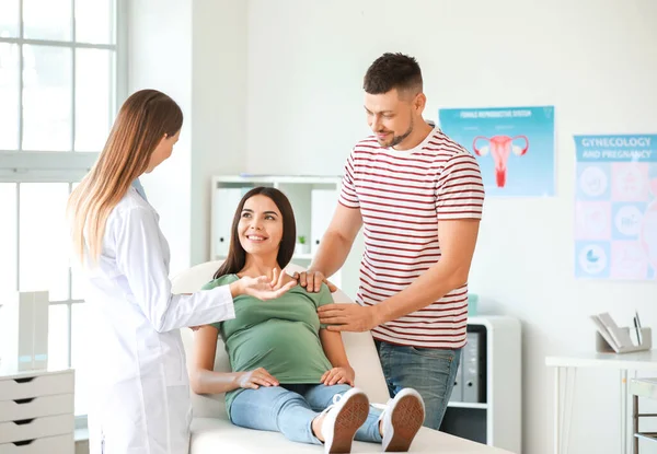 Zwanger paar op bezoek vrouwelijke gynaecoloog in kliniek — Stockfoto