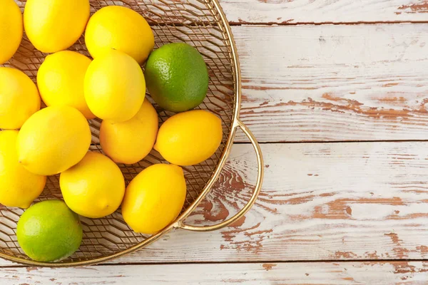 Bandeja con limones maduros y limas sobre fondo de madera — Foto de Stock