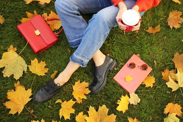 Schöne junge Frau ruht sich im Herbstpark aus — Stockfoto