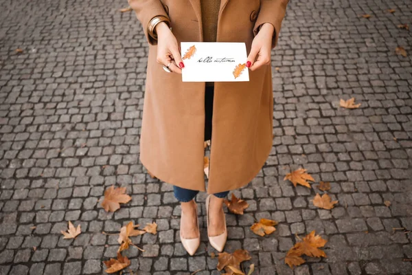 Hermosa joven con tarjeta de felicitación en la ciudad de otoño — Foto de Stock