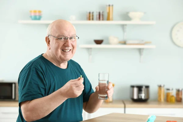 Idoso tomando remédio em casa — Fotografia de Stock