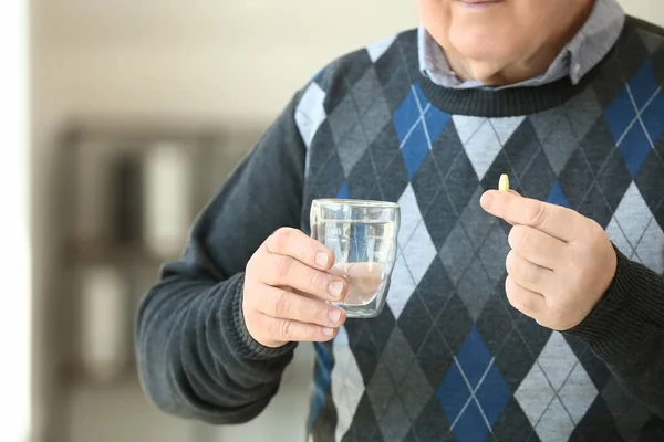 Elderly man taking medicine at home, closeup — Stock Photo, Image