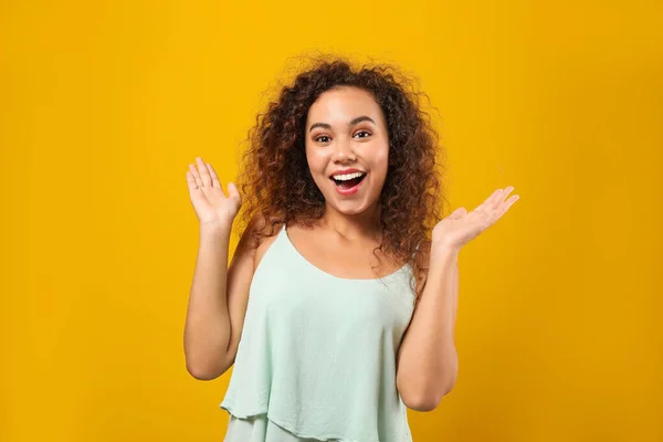 Portrait of happy African-American woman on color background — Stock Photo, Image