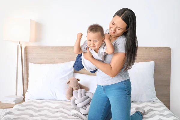 Asian mother and cute little baby playing on bed — Stock Photo, Image