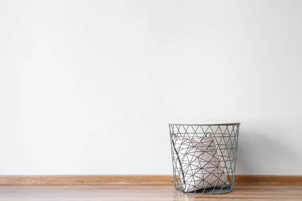 Pillow in basket near white wall — Stock Photo, Image