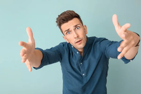 Surprised young man on color background — Stock Photo, Image