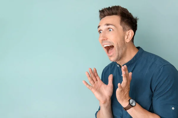 Screaming young man on color background — Stock Photo, Image