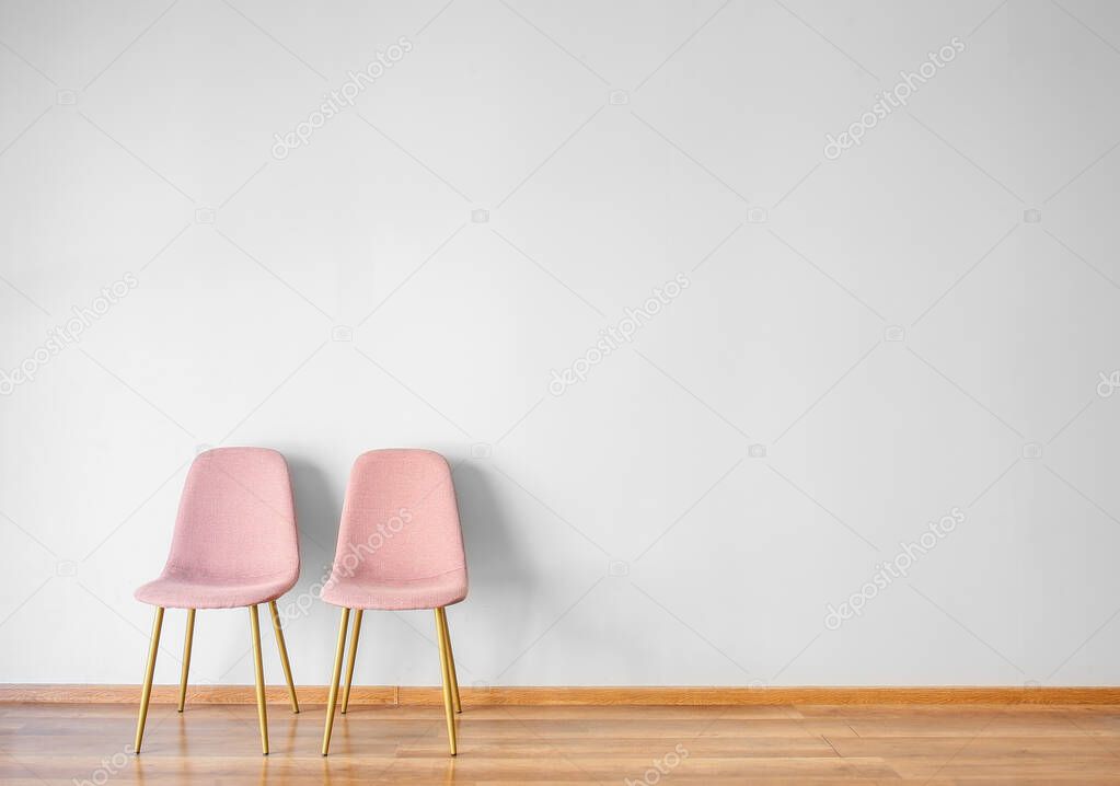 Stylish chairs near white wall