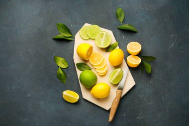 Koyu arkaplanda olgun limonlar ve limonlarla kesme tahtası