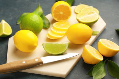 Koyu arkaplanda olgun limonlar ve limonlarla kesme tahtası