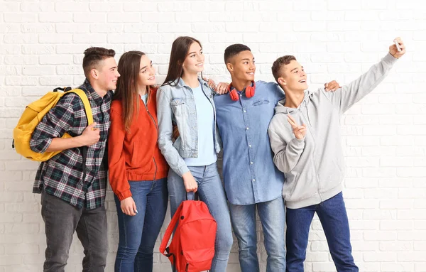 Retrato de adolescentes tomando selfie perto da parede de tijolo branco — Fotografia de Stock