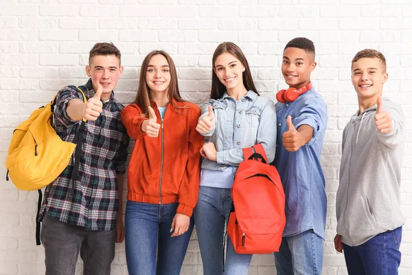 Portrait of teenagers showing thumb-up near white brick wall — Stock Photo, Image