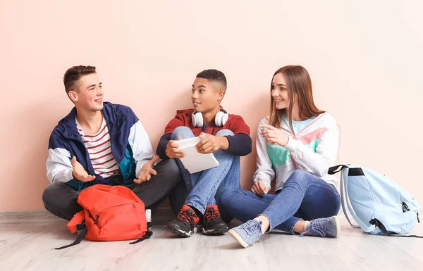 Portrét teenagerů sedících u barevné stěny — Stock fotografie