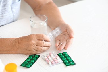 Evde ilaçlı yaşlı bir kadın, yakın plan.