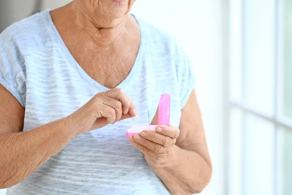 Elderly woman taking medicine at home, closeup — Stock Photo, Image
