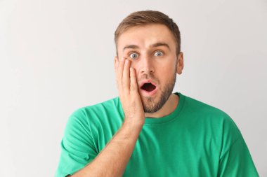 Işık arka plan üzerinde şok genç adam