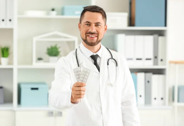 Retrato de médico masculino com pílulas na clínica — Fotografia de Stock