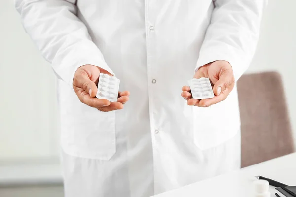 Médico masculino con pastillas en la clínica, primer plano —  Fotos de Stock