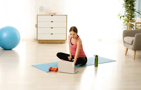 Giovane donna sportiva con laptop a casa — Foto Stock