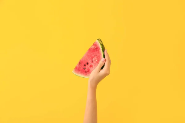 Female hand with piece of juicy watermelon on color background — Stock Photo, Image