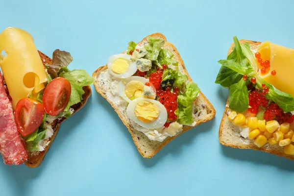 Вкусные бутерброды на цветном фоне — стоковое фото