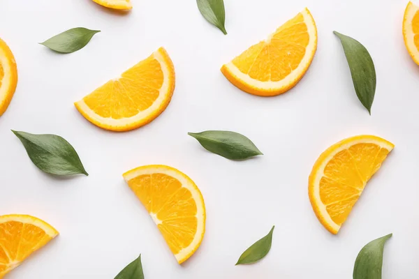 Свіжі апельсинові скибочки з листям на білому фоні — стокове фото