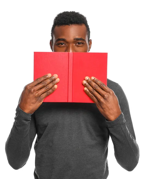 Bonito homem afro-americano com livro sobre fundo branco — Fotografia de Stock