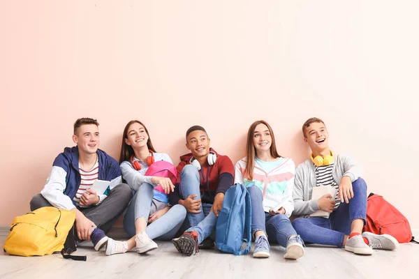 Retrato de adolescentes sentados cerca de la pared de color —  Fotos de Stock