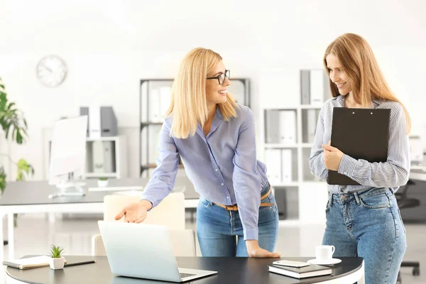 Beautiful businesswoman and her colleague discussing issue in office — Stock Photo, Image