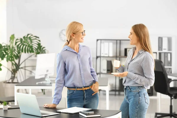 Beautiful businesswoman and her colleague discussing issue in office — Stock Photo, Image