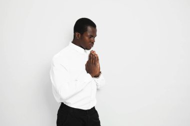 Beyaz arka plan için dua eden yakışıklı Afro-Amerikalı iş adamı
