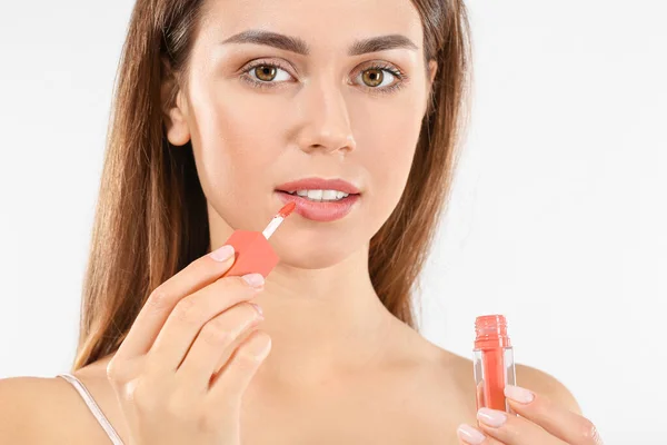 Beautiful young woman with lipstick on light background — Stock Photo, Image