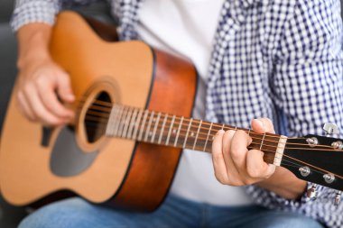 Evde gitar çalan adam, yakın plan.