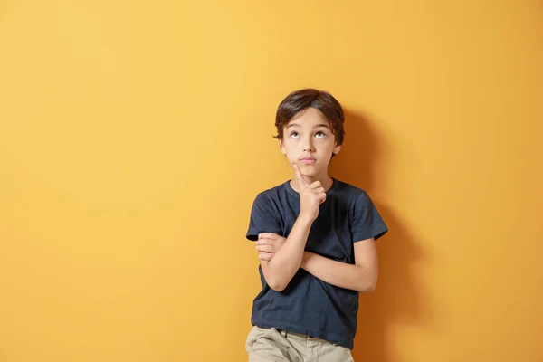 Thoughtful little boy on color background — Stock Photo, Image