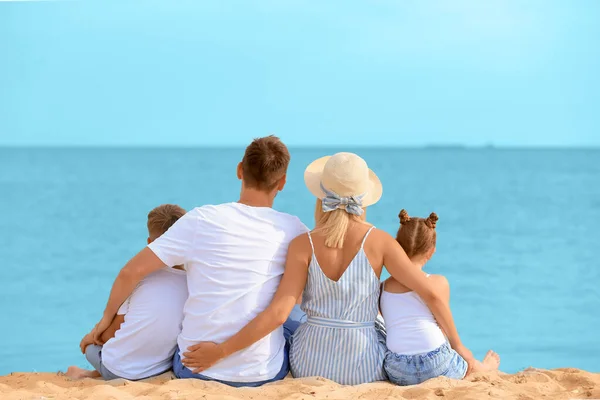 Mutlu aile deniz kıyısında oturuyor. — Stok fotoğraf
